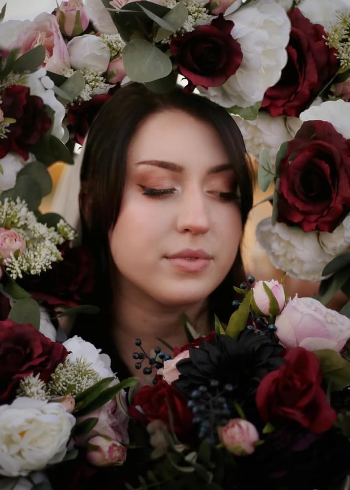 women looking through a flower arrangement 