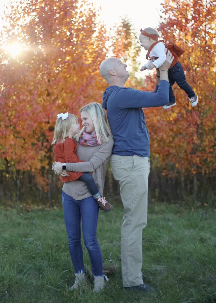 man and women each holding young girls ones an infant and one a toddler. 
